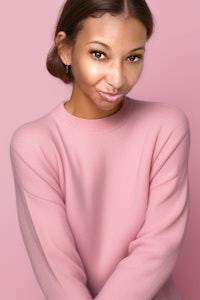 a young woman in a pink sweater posing for a photo